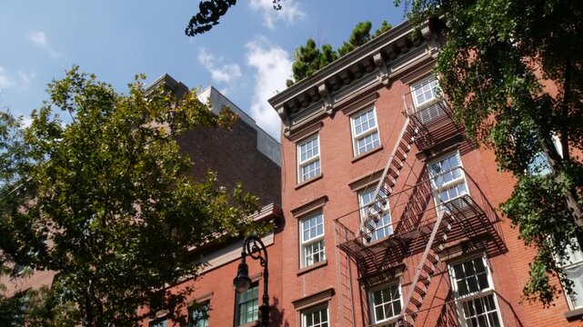New York City urban residential buildings architecture, Manhattan classic street, United States of America. Typical red brick house in NYC, real estate property in USA. Fire escape metallic ladder.