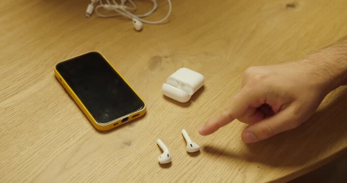 Old wired earphones being replaced by modern wireless earbuds next to a smartphone, representing technology evolution and digital innovation.