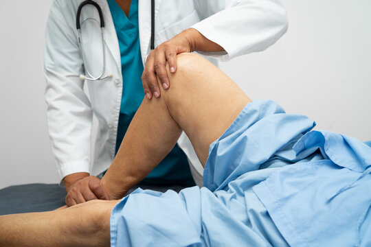 Doctor check Asian elderly woman patient knee joint replacement Suture wound surgery arthroplasty on bed in hospital,