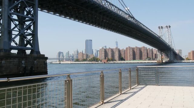 Williamsburg Bridge in Brooklyn, New York City, United States. Transport metallic bridge near Marcy Av subway station and Domino park in Williamsburg. World Trade Center skyscraper tower on Manhattan.