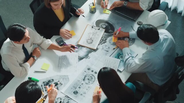 Group of diverse team planning strategy while sitting at table with project plan. Top aerial view of smart business people working together to brainstorm and design house construction. Alimentation.