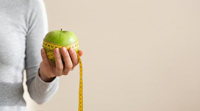 Hand Holding Fresh Green Apple Wrapped in Yellow Measuring Tape Healthy Diet