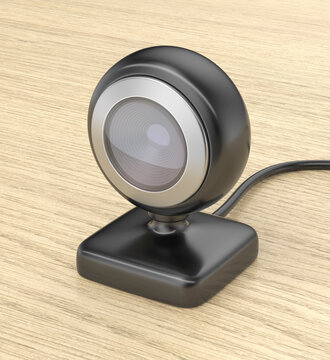 Black webcam or baby monitor on wooden table