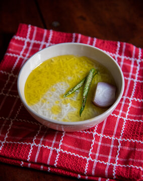 Panta bhat or pakhala or fermented rice soup with water, green chillies and onion in a bowl. Staple food in Eastern India. Close up, selective focus.