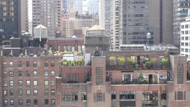 New York City Midtown East urban residential buildings, red brown brick architecture, Manhattan rooftop, United States of America. Water towers on roof. Cityscape with classic water tanks, Turtle Bay.