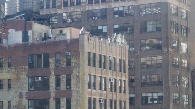 New York City Midtown urban residential building, red brown brick architecture, Manhattan rooftop, United States of America. Water tower on roof. Classic water tanks. Hells Kitchen Port Authority area