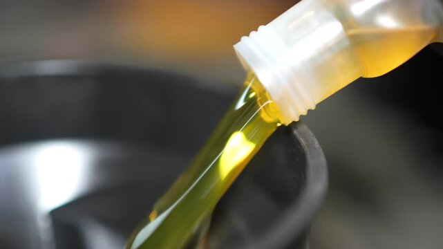 Pouring Motor Oil into Engine - Car Maintenance Process, This video clip shows a close-up view of motor oil being poured from a bottle into an engine's oil filler cap