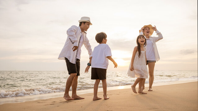 Golden sunset at beach capturing essence of family's summer holiday. Parents playfully engage with their kids in ocean creating moments of bonding joy and carefree fun. delightful weekend scene.