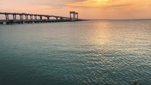Pamban Railway Bridge at sunset, stretching across the calm waters near Rameswaram, Tamil Nadu, India, with warm golden light reflecting across the sea.