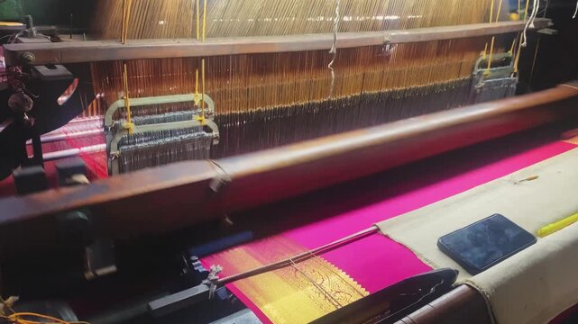 4K video of a colorful saree being woven on a power loom, showcasing the textile manufacturing process and industrial production of traditional Indian clothing.