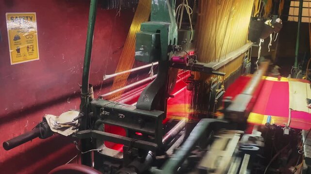4K video of a colorful saree being woven on a power loom, showcasing the textile manufacturing process and industrial production of traditional Indian clothing.