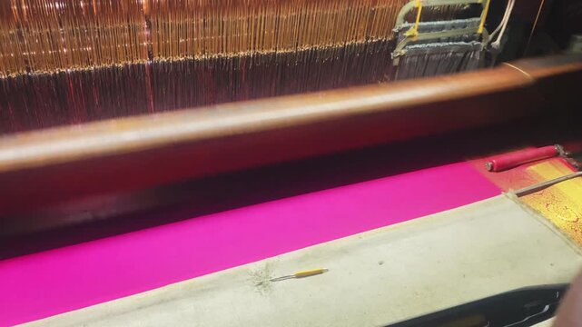 4K video of a colorful saree being woven on a power loom, showcasing the textile manufacturing process and industrial production of traditional Indian clothing.