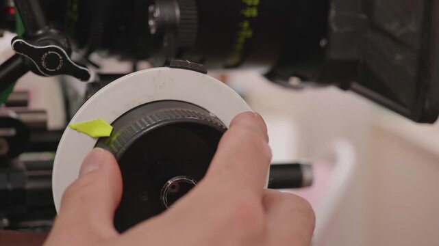 Focus Puller Adjusting Follow Focus Wheel on Professional Film Set