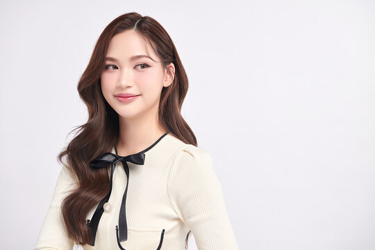 A beautiful young Asian woman with clean, fresh skin against a white background. Skincare, facial treatment, cosmetology, beauty, and spa. An elegant portrait of an Asian woman.