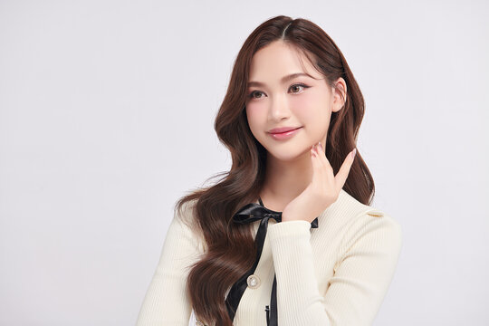 A beautiful young Asian woman with clean, fresh skin against a white background. Skincare, facial treatment, cosmetology, beauty, and spa. An elegant portrait of an Asian woman.