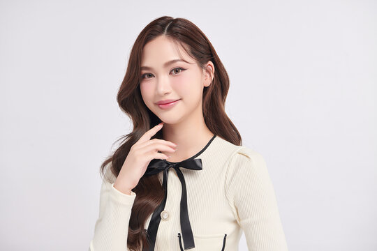 A beautiful young Asian woman with clean, fresh skin against a white background. Skincare, facial treatment, cosmetology, beauty, and spa. An elegant portrait of an Asian woman.