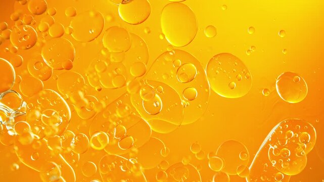 Super Slow Motion Shot of Real Golden Oil Bubbles Floating in Water at 1000fps.