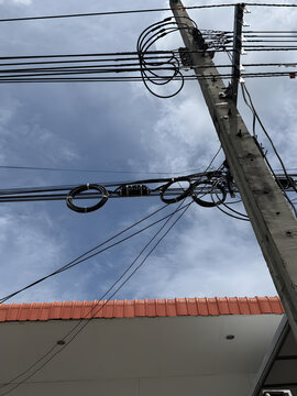 Tangled Electrical Wires Against Blue Sky