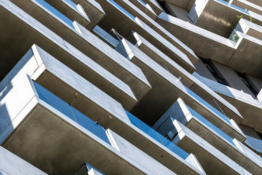 Repeating concrete balconies seen from below create a dramatic geometric pattern with strong lines and abstract building architecture