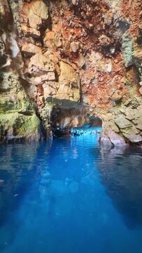 Odysseus Cave with crystal clear blue water on Mljet island in Croatia. Camera panning inside natural sea cave reveals rocky walls and turquoise water