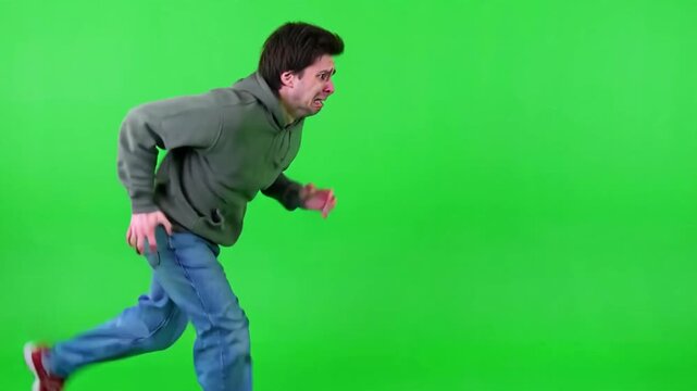 Man running away fast in panic on green screen background