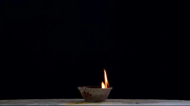 Flames are burning in a bowl isolated on a black background. Concept of particles, sparkles, flame and light.