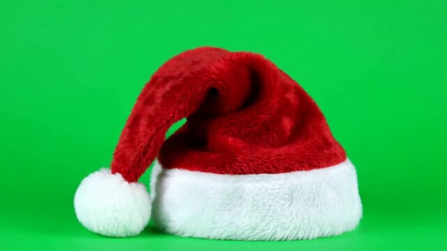 Red Santa hat with white fur trim on green screen background