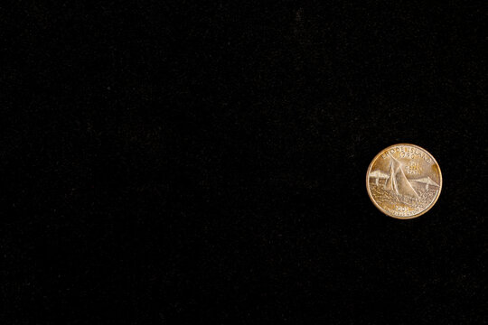 a 25 cent coin on a deep black background