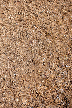 Processed wood chips and shredded wood biomass used as renewable fuel for heating, showing recycled forestry and woodworking material prepared for biomass energy production.