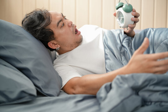Young man having trouble waking up in early morning 
