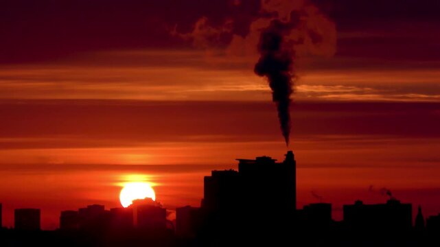 Close-up of the sun during a heat wave, with city buildings emitting smog, smoke, and pollution.