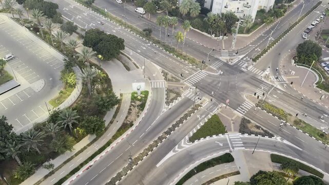 Netanya, Israel, 21 September 2026. View of a deserted intersection during Yom Kippur, with unidentified children riding bicycles and scooters around the traffic circle at dusk, with streetlights illu