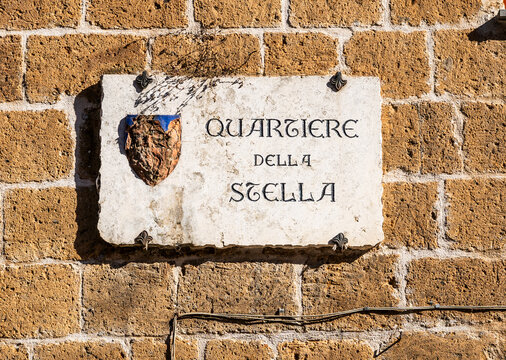 Street sign marking the Quartiere della Stella, one of the historic districts of Orvieto's medieval centre, reflecting the traditional urban organization of the hilltop city, Orvieto, Umbria, Italy
