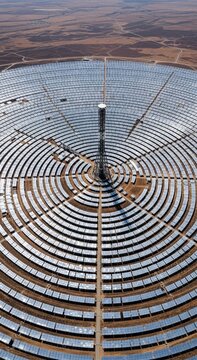 Renewable Energy Future aerial view of a concentrated solar power plant with circular heliostat mirrors in a desert landscape ideal for sustainability reports.