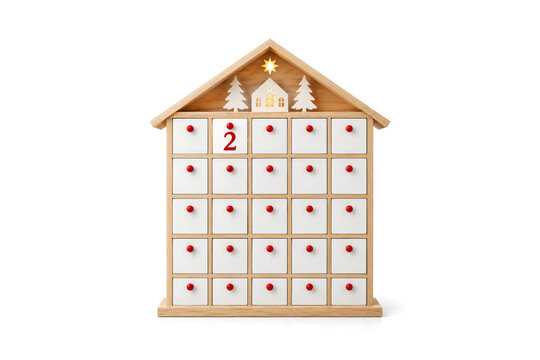 Wooden house shaped advent calendar with white drawers and red knobs counting down to a holiday. December 2 Christmas celebration concept