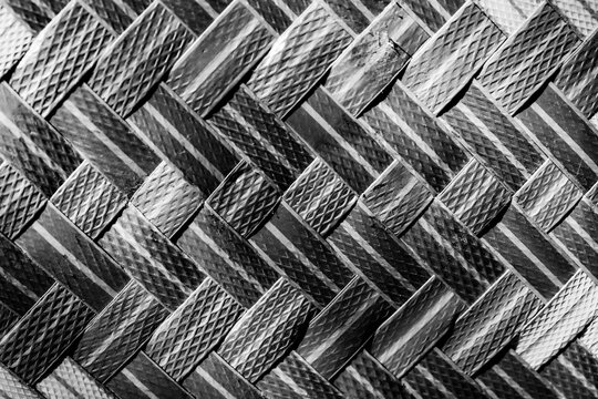 Monochrome woven bamboo mat (besek/gedek) with a traditional geometric zig-zag pattern.