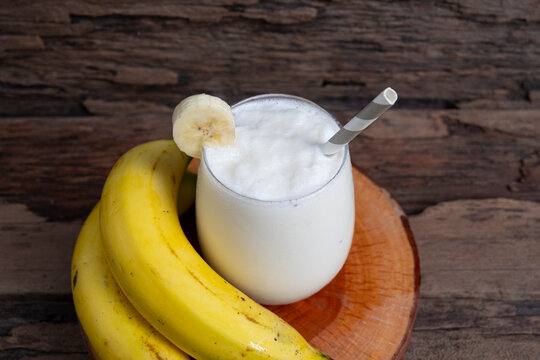 Banana fresh cocktail vanilla smoothies  fruit juice beverage healthy the taste yummy in glass drink episode good morning on wooden background from the top view.