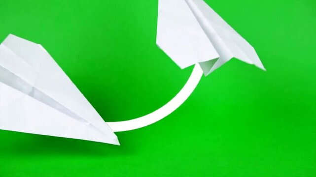 Paper airplane flying across on green screen background