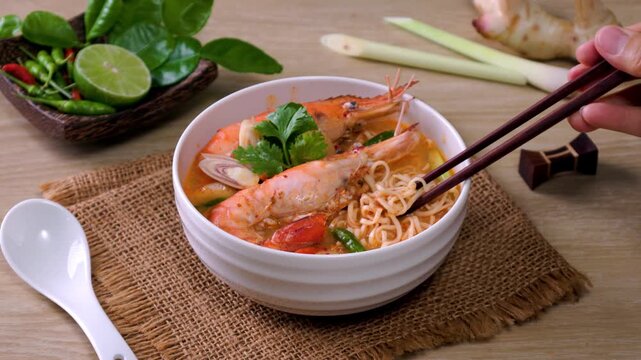 Instant noodles, Tom Yum Goong spicy shrimp soup In a white bowl. on a wooden table