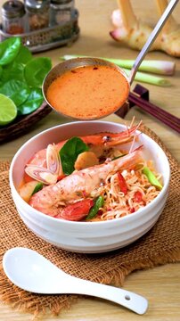 Instant noodles, Tom Yum Goong spicy shrimp soup In a white bowl. on a wooden table