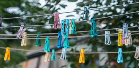 Many Different Colored Clothespins Hanging On Wires In The Garden © Anastasia