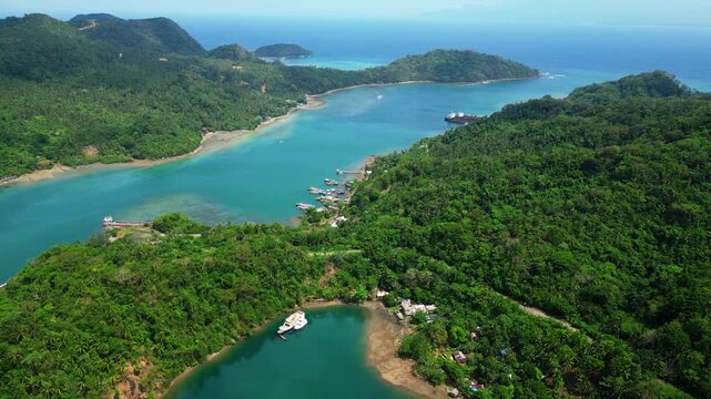 Sunny aerial landscape of Sula Bridge and Angel's Corner along Misibis Road, capturing the contrast between the road, tropical vegetation and bright blue lagoon waters of Cagraray Island, Bacacay.