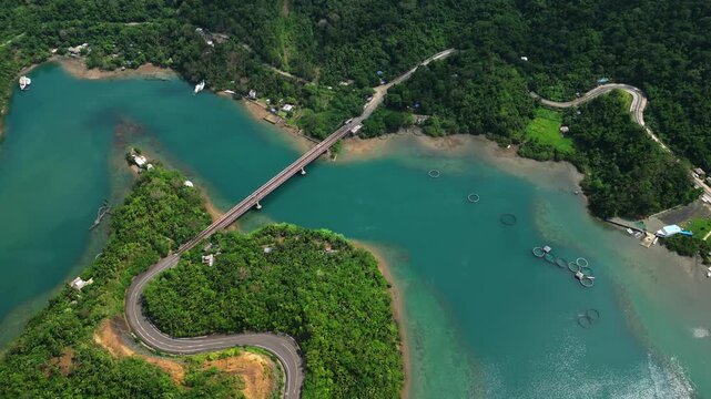 Sunny top-down aerial view of Sula Bridge and Angel's Corner along Misibis Road on Cagraray Island, Bacacay, Albay, revealing vivid blue lagoon waters and tropical scenery.