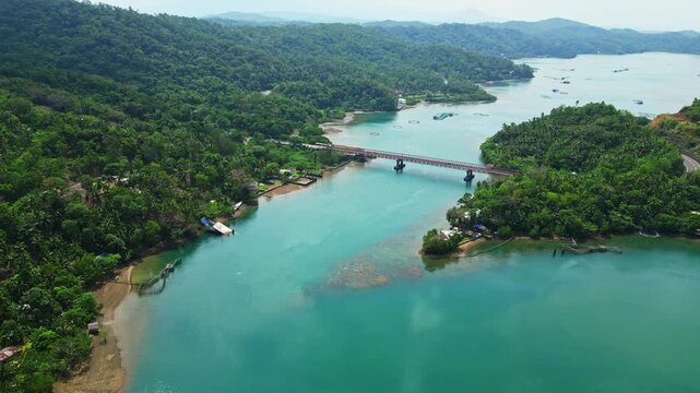 High aerial perspective over Sula Bridge and Misibis Road, showing Angel's Corner surrounded by brilliant blue lagoon waters and the tropical landscape of Cagraray Island.