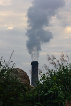 Climate change and air pollution, industrial smoke stack emitting carbon emissions into the sky