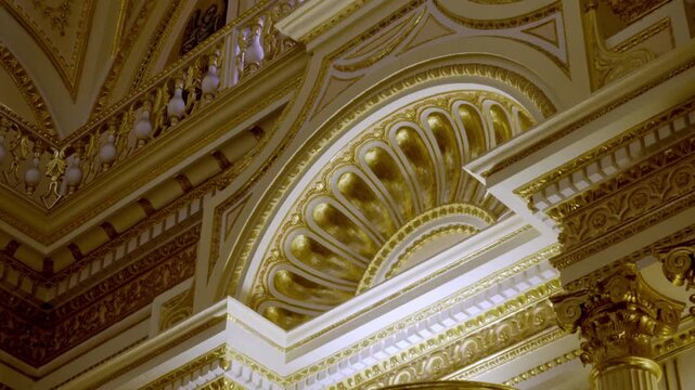 Ornate gold architectural interior with a richly decorated arch, carved details and classical columns. Intricate gilded ornament creates an elaborate historic setting in Mexico.