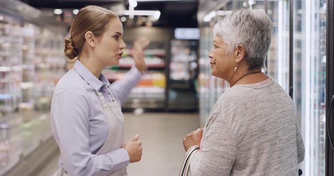 Supermarket, store assistant and senior woman with help, groceries and service with consumer support. Question, guidance and person with pensioner for customer experience, direction and aisle in shop