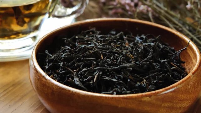 Dried black tea leaves in a wooden bowl