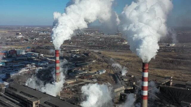 Smokestacks emitting smoke.
