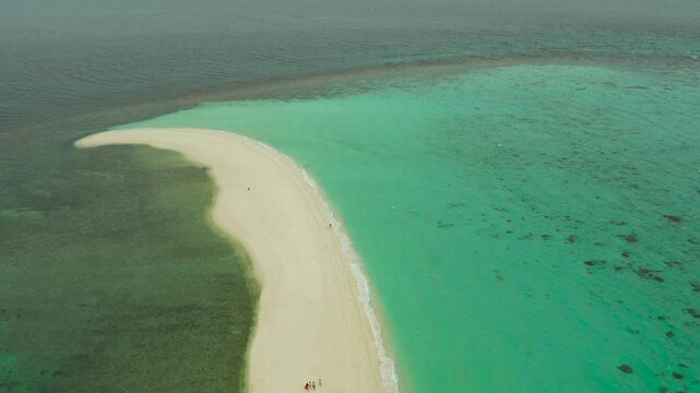 Tropical white island and sandy beach with tourists surrounded by coral reef and blue sea, aerial view. Sandbar Atoll. Island with sand bar and coral reef. Summer and travel vacation concept, Camiguin